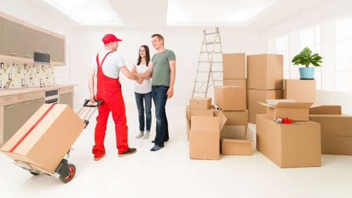 Local moving team loading furniture into a van in Acton